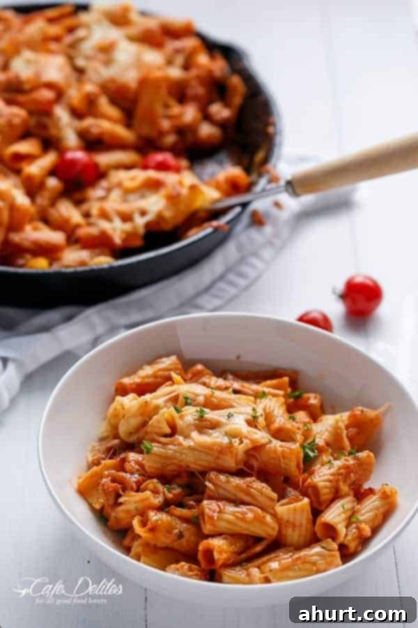 Cheesy Chicken and Roasted Tomato Mozzarella Pasta Bake in a pan and some taken into bowl