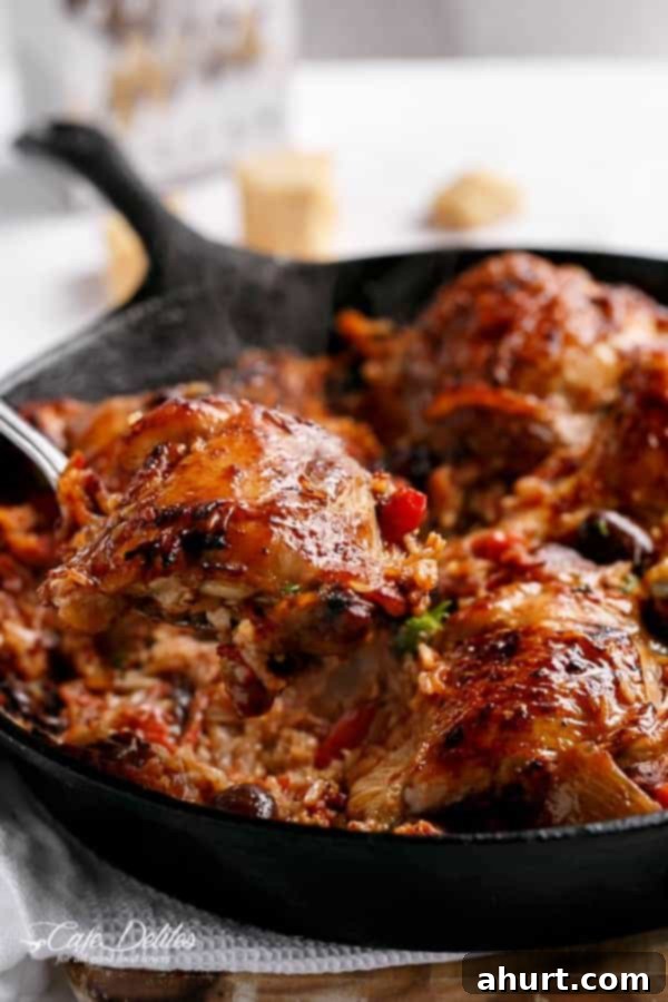 Tuscan Chicken and Rice Skillet 3 A spoon holding chicken piece from One Pot Italian Sundried Tomato Chicken and Rice
