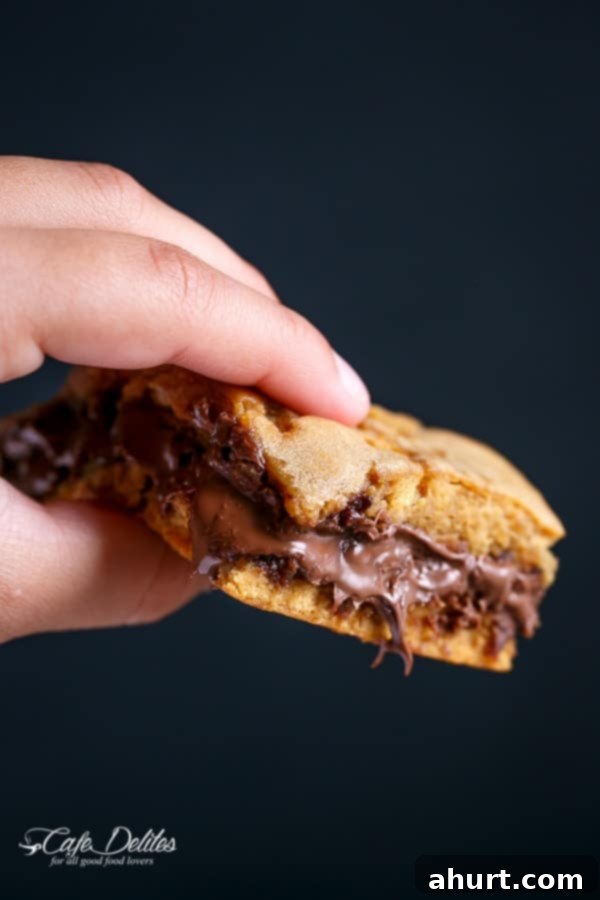 Gooey Nutella Stuffed Salted Caramel Blondies 9 A fingers holding a piece of Nutella Stuffed Salted Caramel Blondies