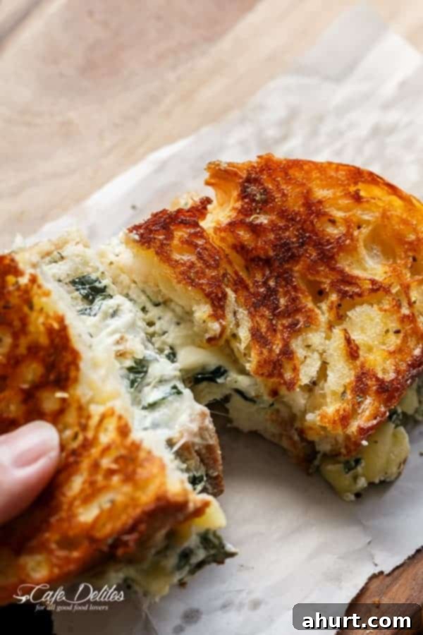 Creamy Spinach and Ricotta Grilled Cheese 6 Close-up of a half Spinach and Ricotta Grilled Cheese on wax paper