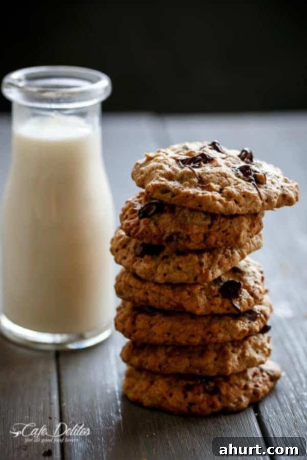 Flourless Oatmeal Peanut Butter Chocolate Chip Cookies stack on each other with a bottle filled with milk on the sides  