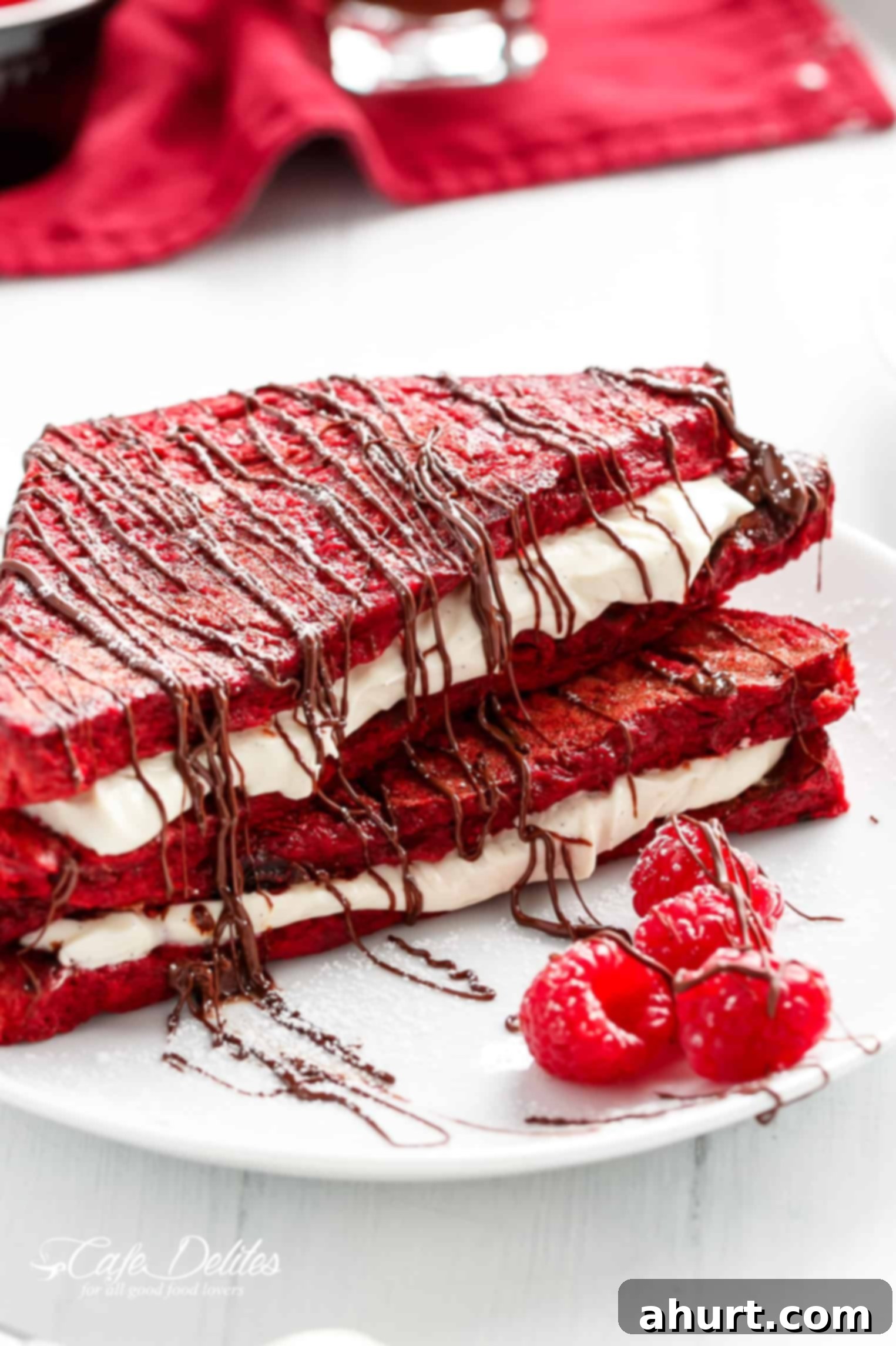Stacked slices of Red Velvet French Toast with cheesecake filling, garnished with fresh berries