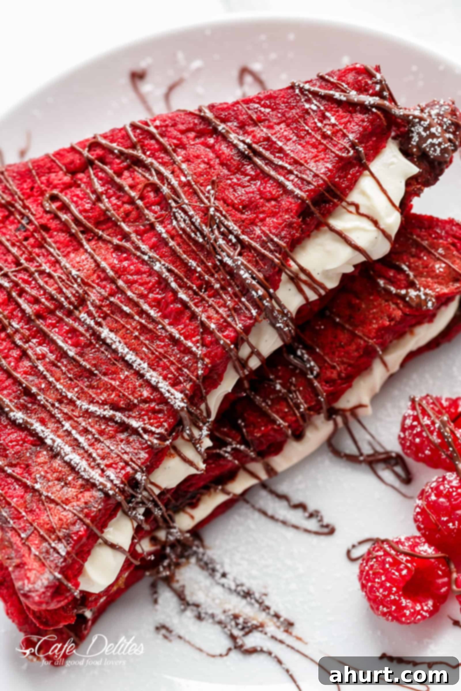 Red Velvet French Toast Cheesecake topped with fresh raspberries and a generous dollop of cream