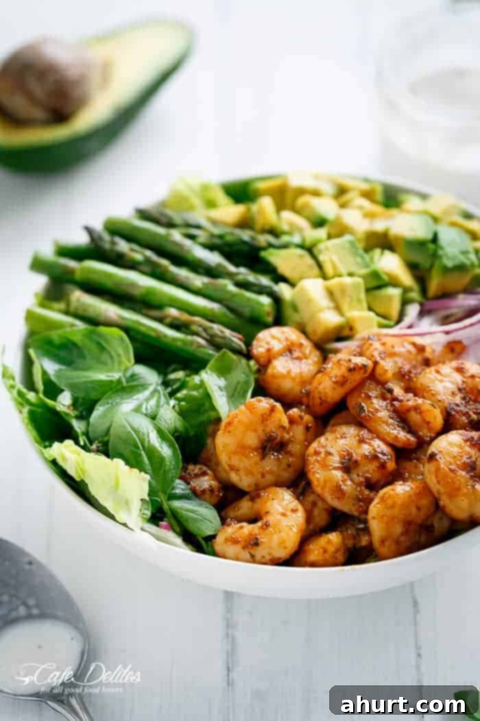 Seared Blackened Shrimp & Vibrant Green Salad 3 Side view of the fresh and colorful Blackened Shrimp, Asparagus & Avocado Salad, highlighting the crisp lettuce and perfectly cooked shrimp and asparagus.