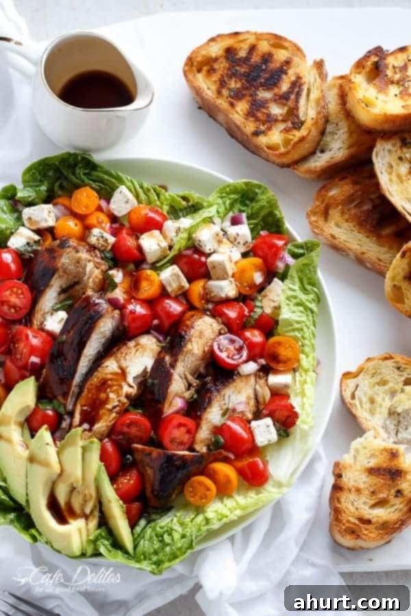 Grilled Balsamic Chicken and Avocado Bruschetta Salad on a plate with some toasted bread slices 