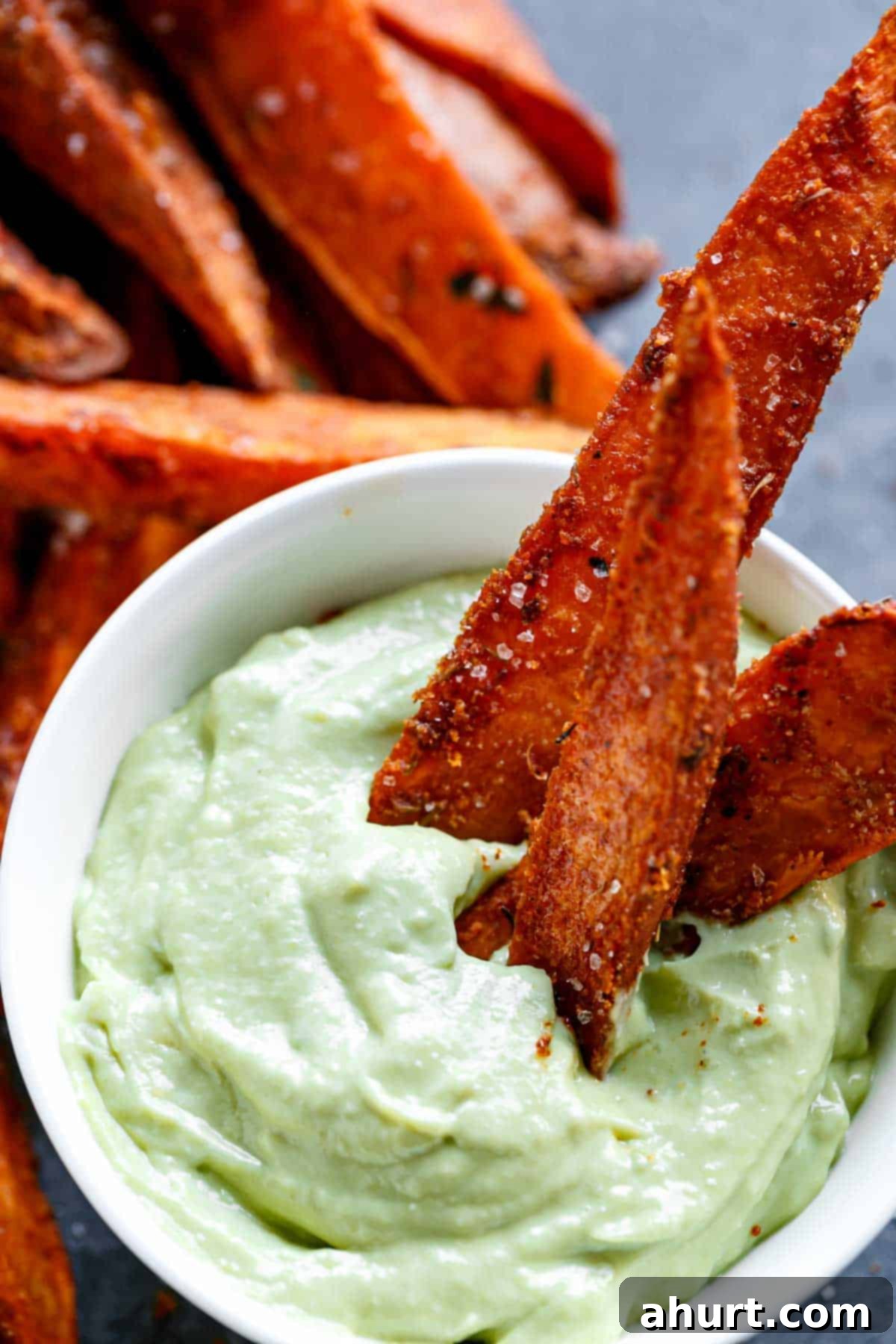 Golden Crispy Sweet Potato Wedges with Creamy Garlic Avocado Aioli 12 A bowl of Crispy Sweet Potato Wedges with Garlic Avocado Aioli, perfectly golden and ready to be enjoyed.