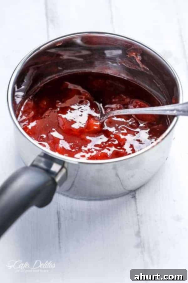 A vibrant mixture of muddled strawberries, mint, and lime with a hint of coconut rum in a clear glass.