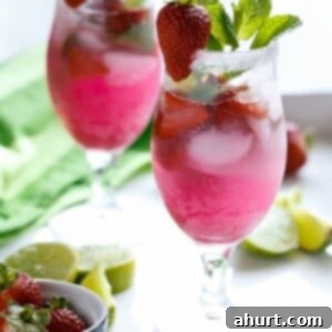 Pink Paradise Coconut Mojito 5 A perfectly prepared Strawberry Coconut Mojito in a glass, garnished with fresh mint and a whole strawberry.