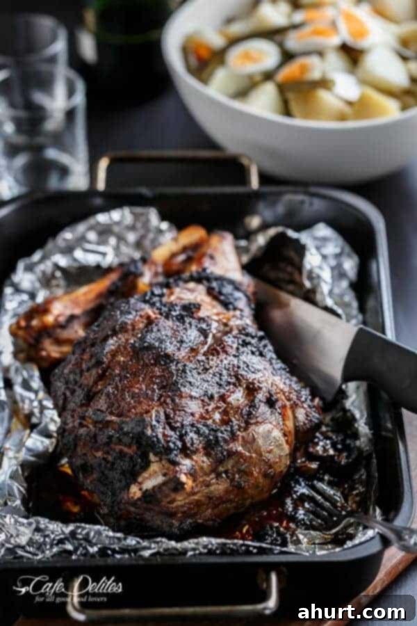 Whole Sundried Tomato and Garlic Roast Lamb, beautifully browned and ready for carving