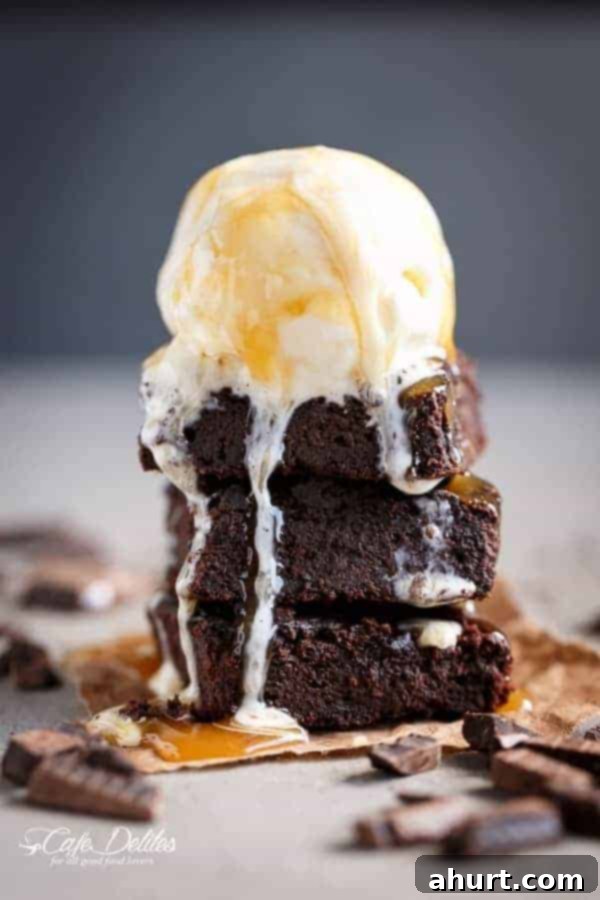 Fudgy Keto Zucchini Brownies 2 Delicious Low Carb Zucchini Brownies served with a scoop of vanilla ice cream, perfect for a healthy dessert.