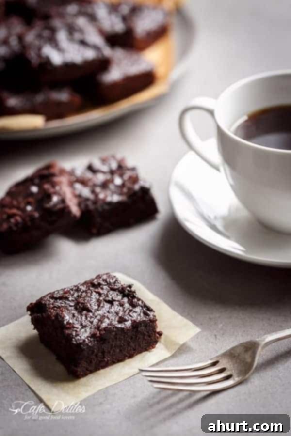 Fudgy Keto Zucchini Brownies 3 Fudgy Zucchini Brownies paired with a cup of black coffee, ideal for a morning treat or afternoon snack.