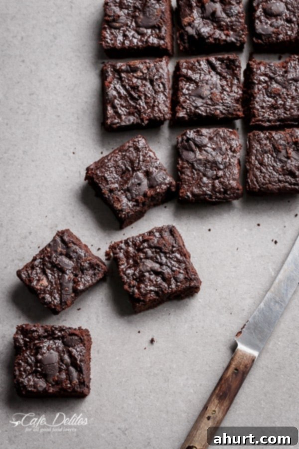 Fudgy Keto Zucchini Brownies 8 A plate of two Low Carb Zucchini Brownies, one with a bite taken, highlighting their appealing texture and taste.