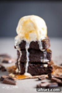 Fudgy Keto Zucchini Brownies 9 Delicious Low Carb Zucchini Brownies served with a scoop of vanilla ice cream, perfect for a healthy dessert.