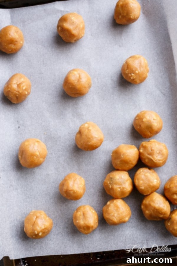 Dough balls for Salted Chocolate Dipped Peanut Butter Cookies on a parchment-lined baking sheet