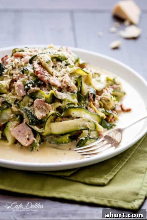 Zoodle Carbonara 2 A vibrant platter of Zucchini (Zettuccine) Carbonara, showcasing perfectly cooked zucchini ribbons, crispy bacon, and a creamy sauce, garnished with fresh herbs and a sprinkle of Parmesan.