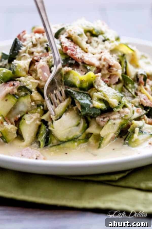 Zoodle Carbonara 11 A beautifully plated dish of Zucchini (Zettuccine) Carbonara, ready to be enjoyed, with a generous topping of freshly cracked black pepper and Parmesan.