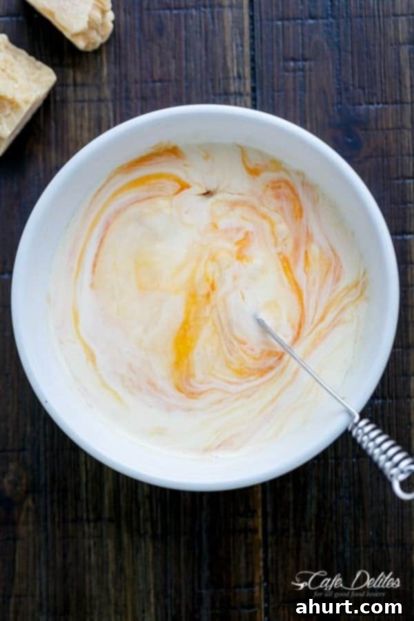 Zoodle Carbonara 9 A bowl containing a whisked egg, cream, and cheese mixture, perfectly smooth and creamy, ready to be added to the pan.
