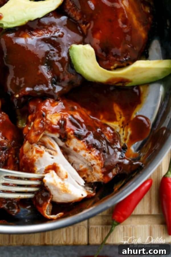Tangy Barbecue Buffalo Chicken Thighs with Creamy Avocado 6 Focus shot on a succulent piece of Crispy Barbecue Buffalo Chicken Thigh, showing its beautiful glaze and crispy texture, alongside creamy avocado.