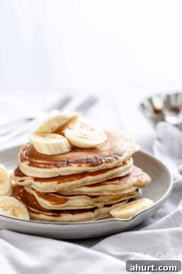 Gooey Nutella Banana Pancake Bliss 6 Nutella Stuffed Banana Pancakes with banana pieces on a plate