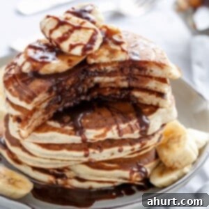 Gooey Nutella Banana Pancake Bliss 9 Nutella Stuffed Banana Pancakes stack on each other on a plate