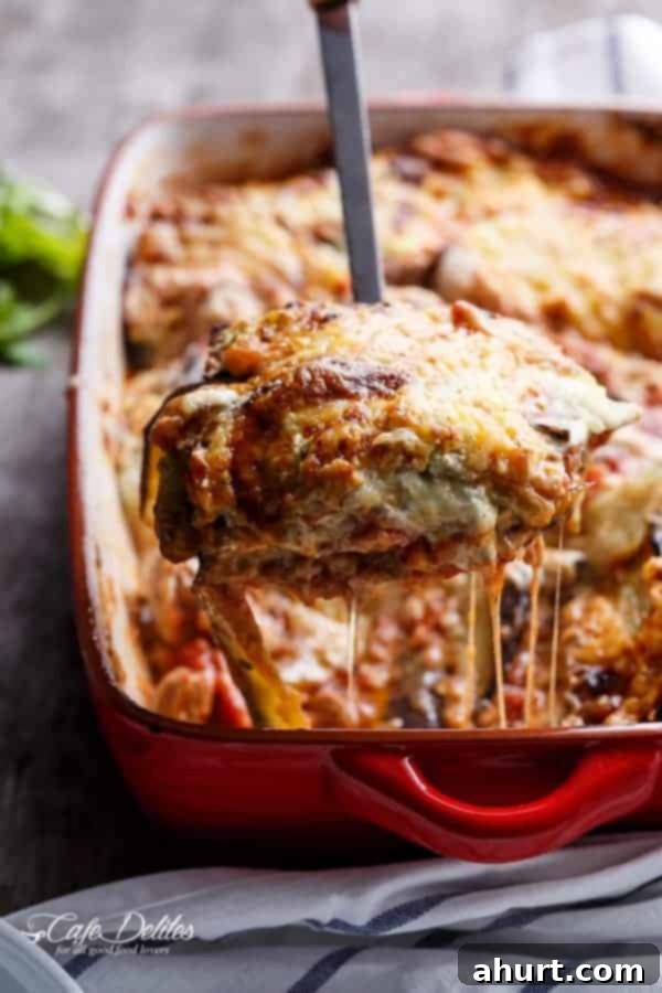 Sausage Eggplant Lasagna With Ricotta Pesto in a baking tray, showing bubbling cheese and rich layers.