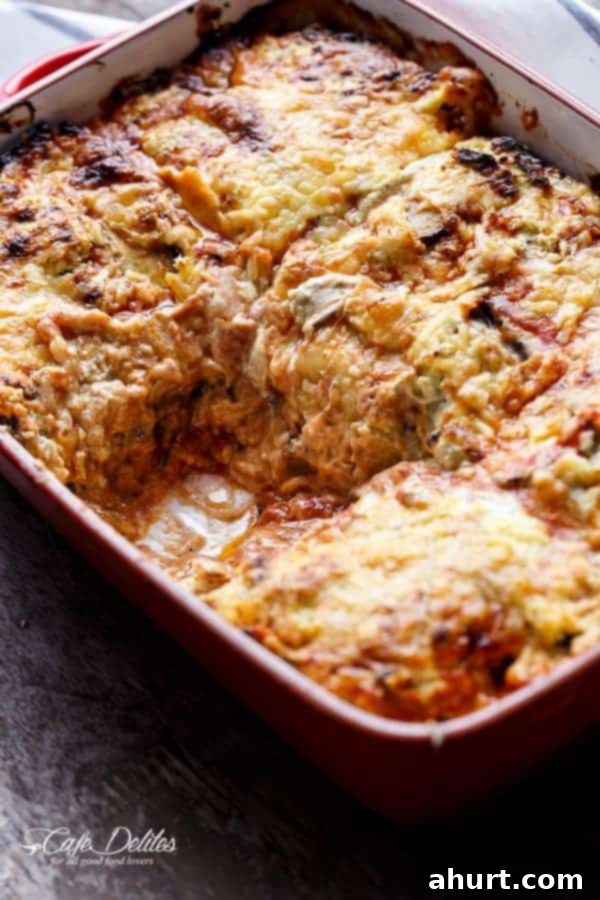 A piece of Sausage Eggplant Lasagna With Ricotta Pesto removed from the dish, highlighting its rich layers and appetizing texture.