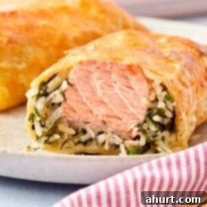Flaky Salmon and Spinach Pockets 13 Close-up of a golden Puff Pastry Salmon Parcel sliced open to reveal flaky salmon, creamy spinach, and rice inside.