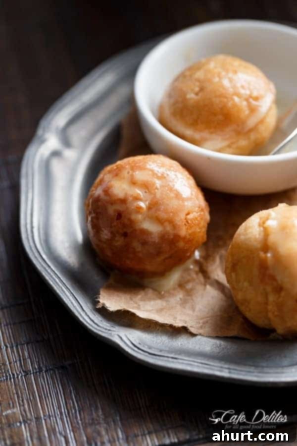 Close-up of fluffy baked apple fritter donut holes with a glossy maple glaze