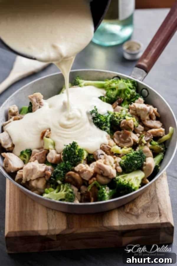 Creamy White Wine Sauce being poured over Chicken and Mushrooms 