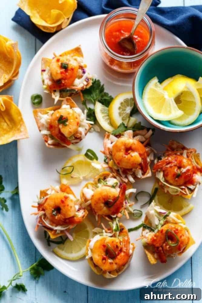 Garlic Prawn (Shrimp) Salad Wonton Cups with Sweet Chilli Sauce with lemon wedges in a small bowl