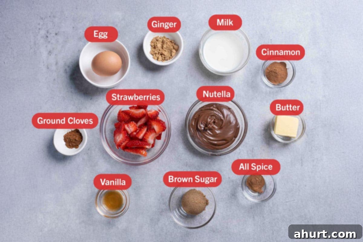 French Toast Rolls Breakfast Perfection 3 A picture of the key ingredients needed to prepare the French Toast Roll-Ups, specifically: one egg, ginger, milk, cinnamon, ground cloves, strawberries, Nutella, butter, vanilla, brown sugar, and allspice arranged neatly on a counter.
