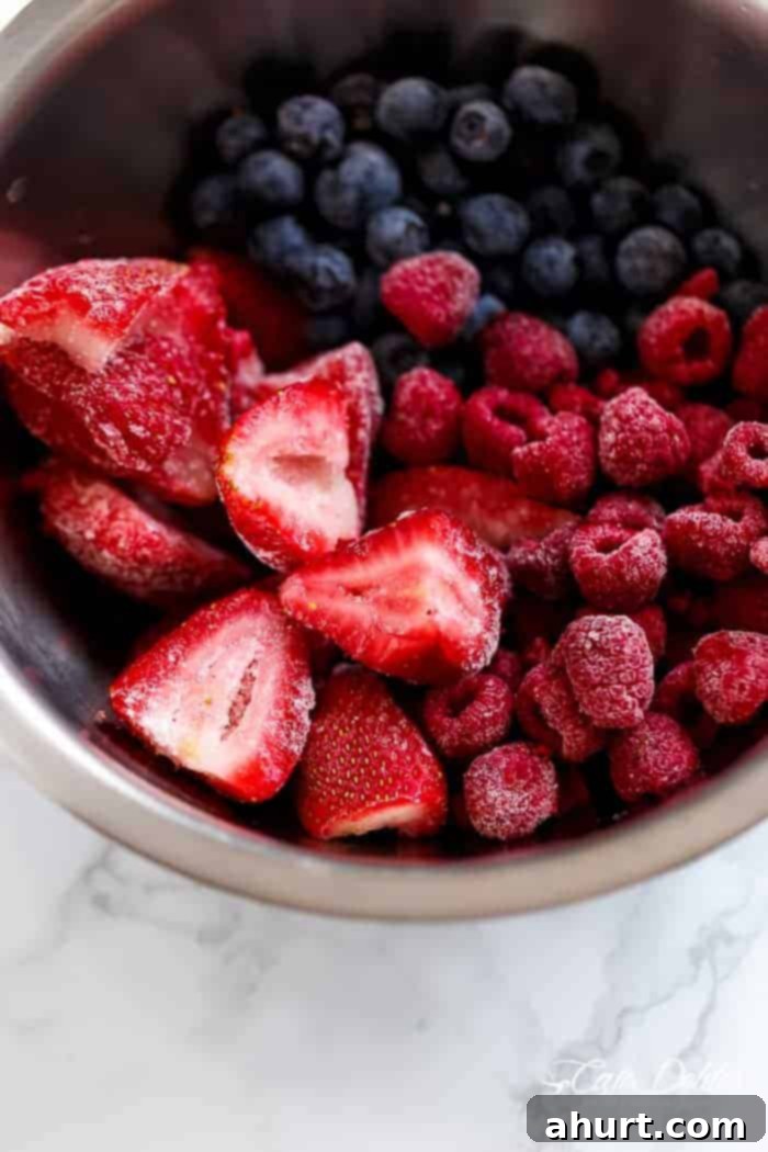 Fresh berries being prepared in a blender for Berry Limoncello Moscato Sangria, highlighting the fresh ingredients.