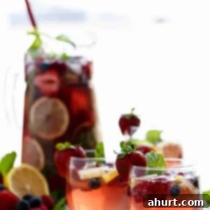 Berry Sangria 7 A glass of Berry Sangria, garnished with mint and a strawberry, a perfect refreshing drink.