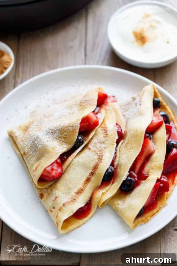 Blender Eggnog Crêpes beautifully dusted with powdered sugar on a plate, ready for a festive breakfast