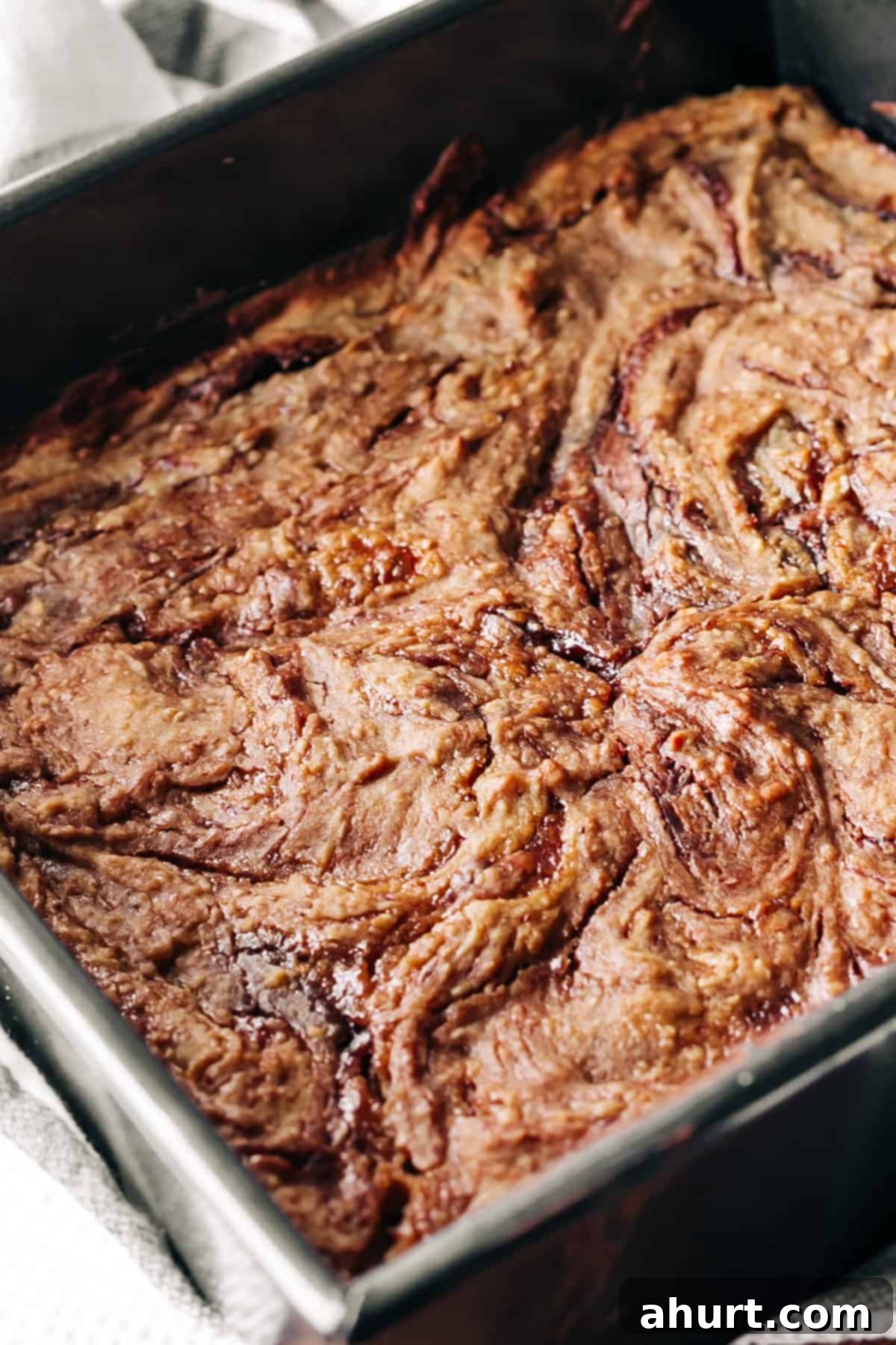 Jam and Nutella swirled blondies in a square baking tray just before baking, showcasing the vibrant swirls