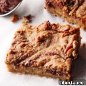 Nutty Fruity Chocolate Banana Blondies 6 Jam and Nutella swirled blondie piece on parchment paper