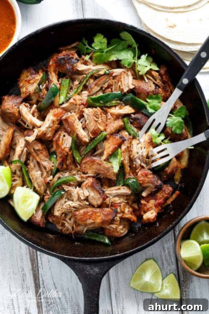 Fork pierced in Crispy Slow Cooker Carnitas in a pan