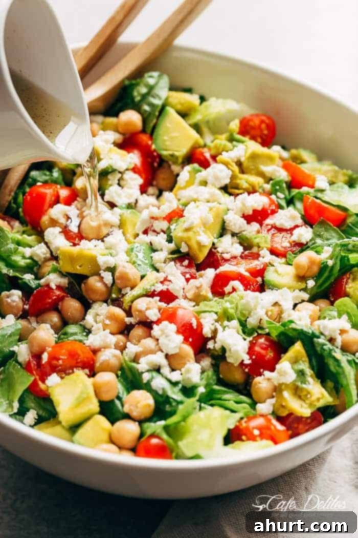 Vibrant Balsamic Chickpea Avocado Feta Salad 7 A rich balsamic dressing being poured over the freshly assembled Balsamic Chickpea Avocado Feta Salad, ready to be tossed.
