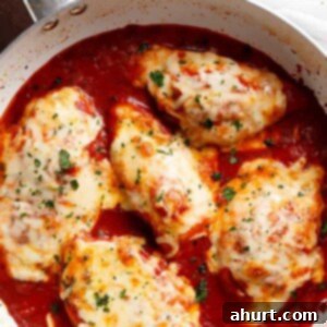 Chicken Mozzarella 11 Skillet Mozzarella Chicken In Tomato Sauce, golden brown and cheesy, ready to be served from a pan.