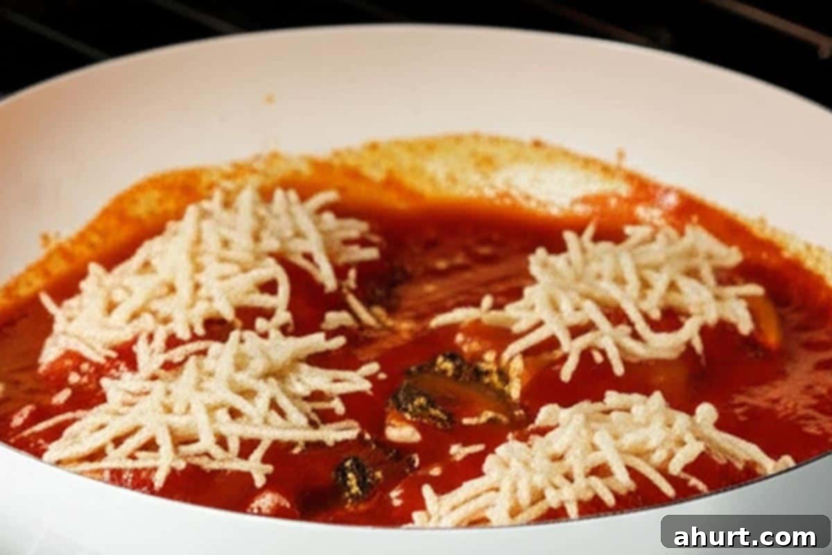 Chicken Mozzarella 8 A chicken fillet covered generously with shredded mozzarella cheese, ready to be broiled for a golden, melted finish.