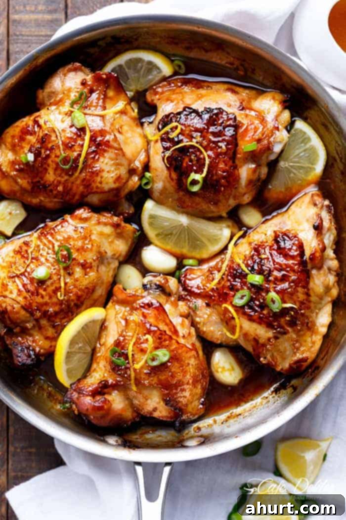 Crispy Honey Lemon Garlic Chicken pieces with fresh lemon wedges in an oven-proof skillet