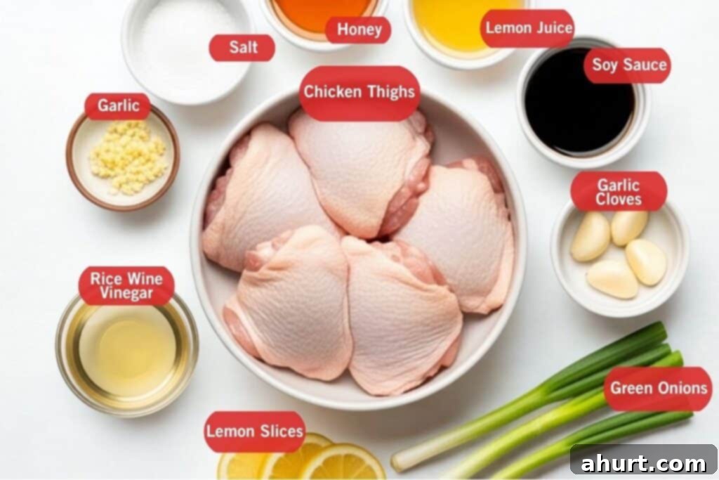 Fresh ingredients laid out for Honey Lemon Garlic Chicken, including chicken thighs, honey, lemons, and garlic cloves.