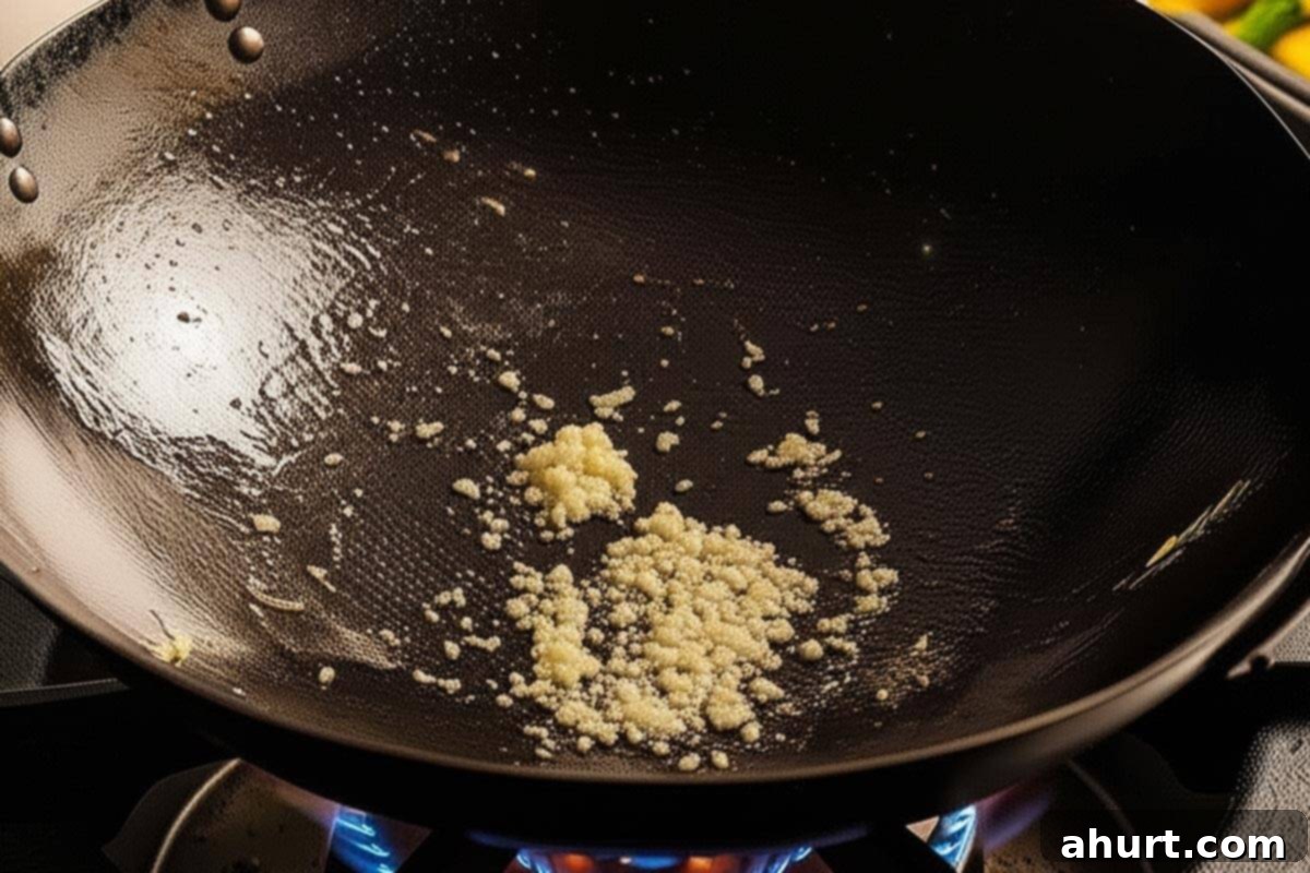 Extra Saucy Mongolian Beef and Broccoli 7 Stir-frying the garlic and ginger in a wok.