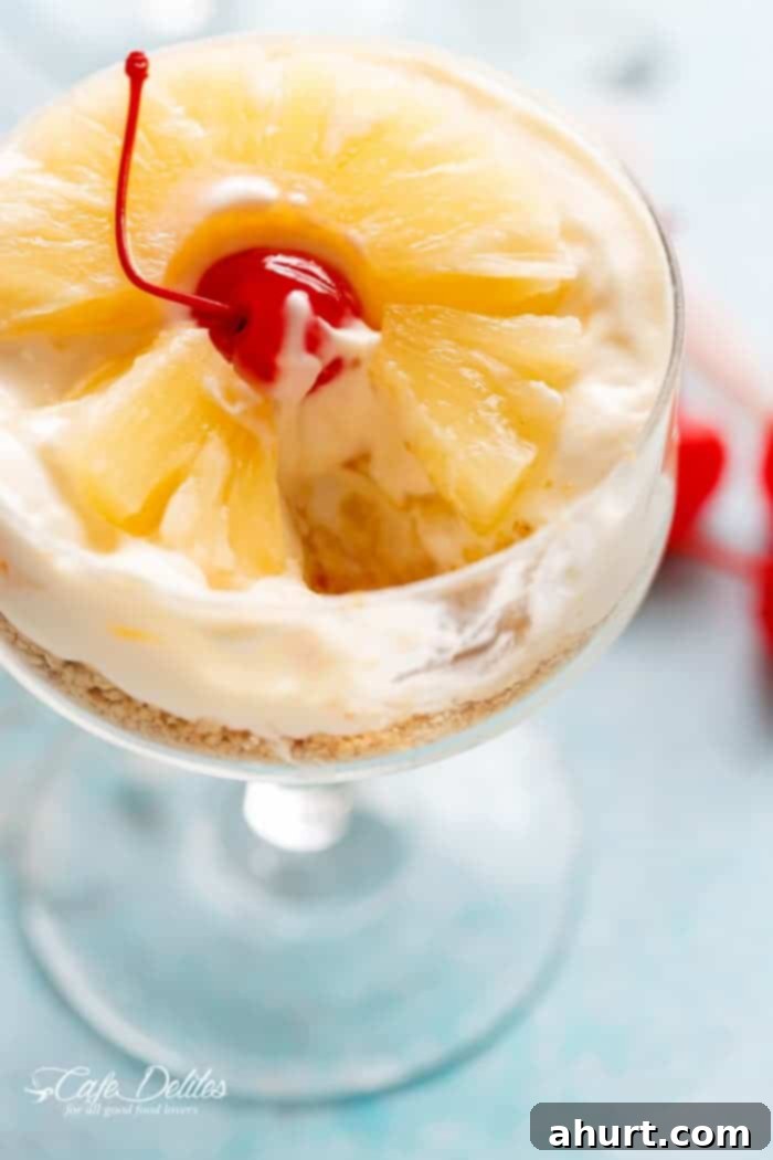 A spoonful of No-Bake Pineapple Cheesecake with visible graham cracker crust, creamy filling, and pineapple pieces