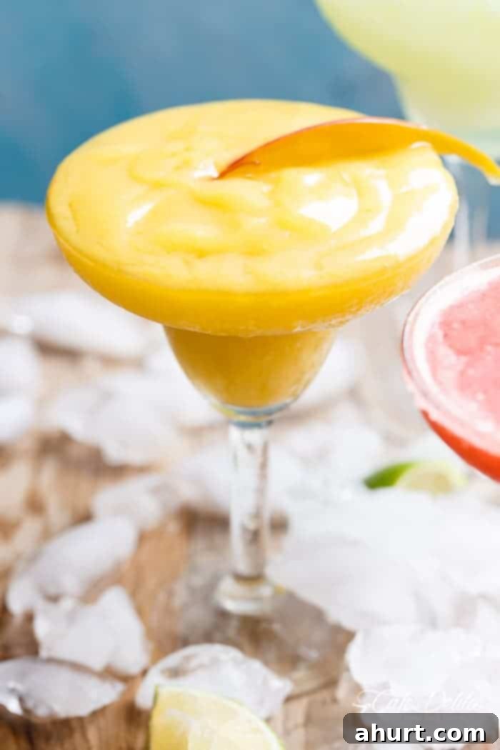 Tropical Strawberry Mango Margaritas 3 A beautifully presented Frozen Mango Margarita in a sophisticated glass, garnished with a lime wedge, highlighting its creamy and boozy texture.