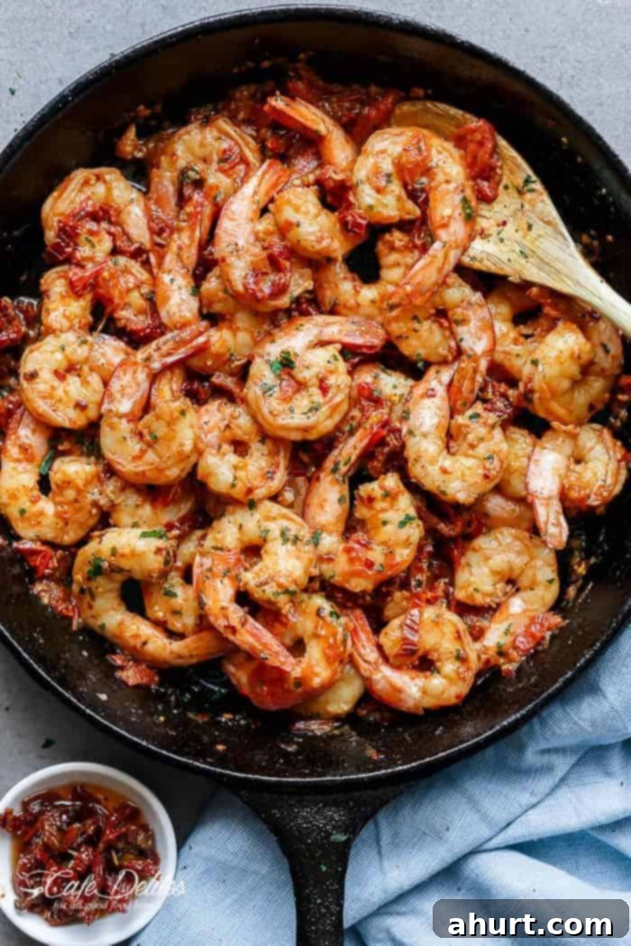 Zesty Sun-Dried Tomato Garlic Shrimp 2 Top view of Spicy Garlic Sun Dried Tomato Shrimp, garnished with fresh basil, served in a white bowl.