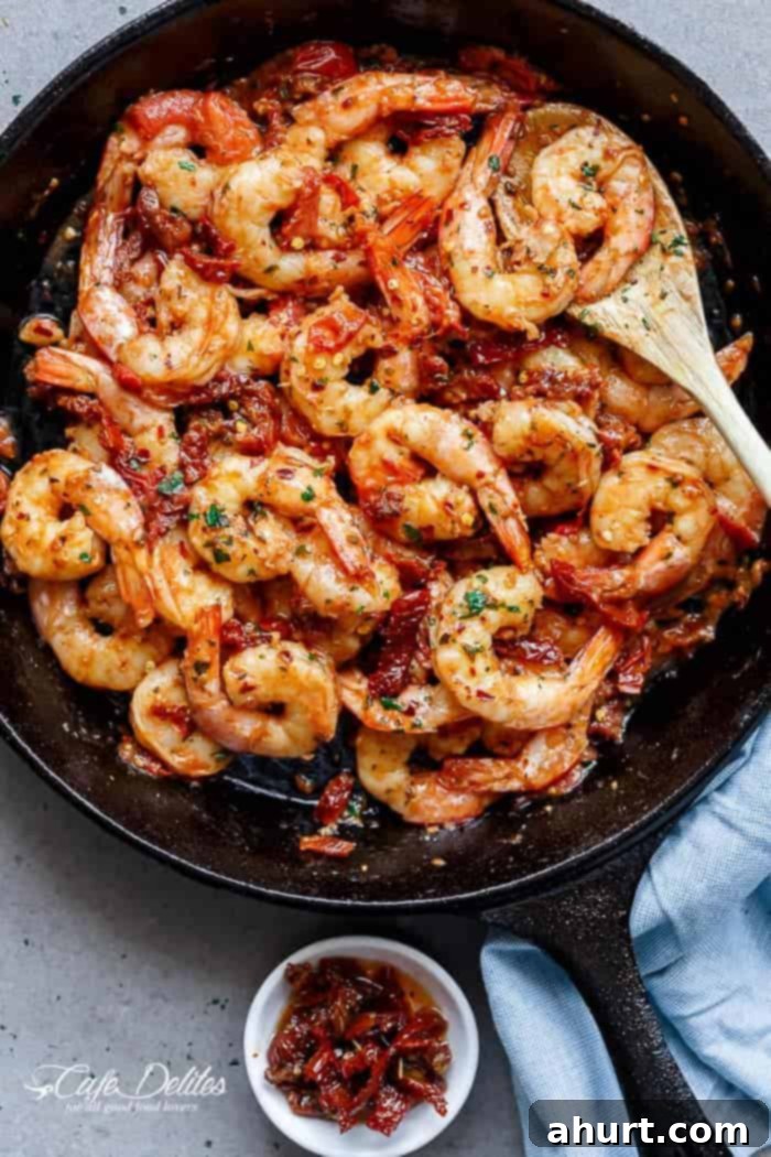 Zesty Sun-Dried Tomato Garlic Shrimp 10 Spicy and garlicky with the subtle sweetness of sun-dried tomatoes shrimp in a pan, still cooking.