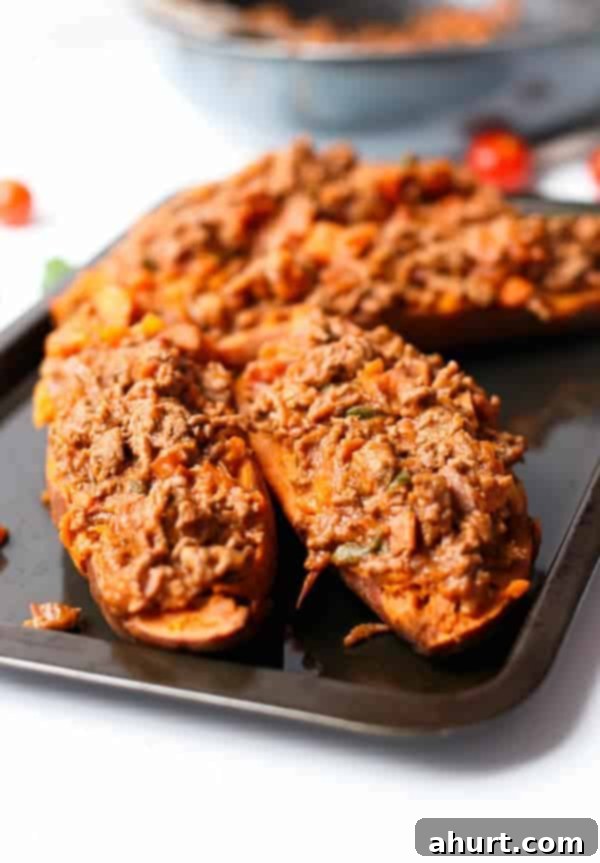 Sweet Potato Boats with Cheesy Bacon Bolognese 5 Raw Bacon Bolognese Stuffed Sweet Potatoes on a baking tray ready to bake