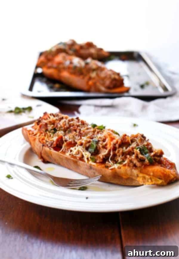 Sweet Potato Boats with Cheesy Bacon Bolognese 7 Bacon Bolognese Stuffed Sweet Potatoes on a plate and 2 pieces on baking tray