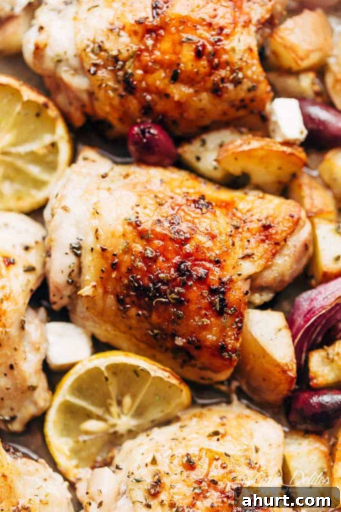 Hellenic Citrus Herb Chicken 3 Close-up image focusing on a single succulent chicken piece with bright lemon wedges